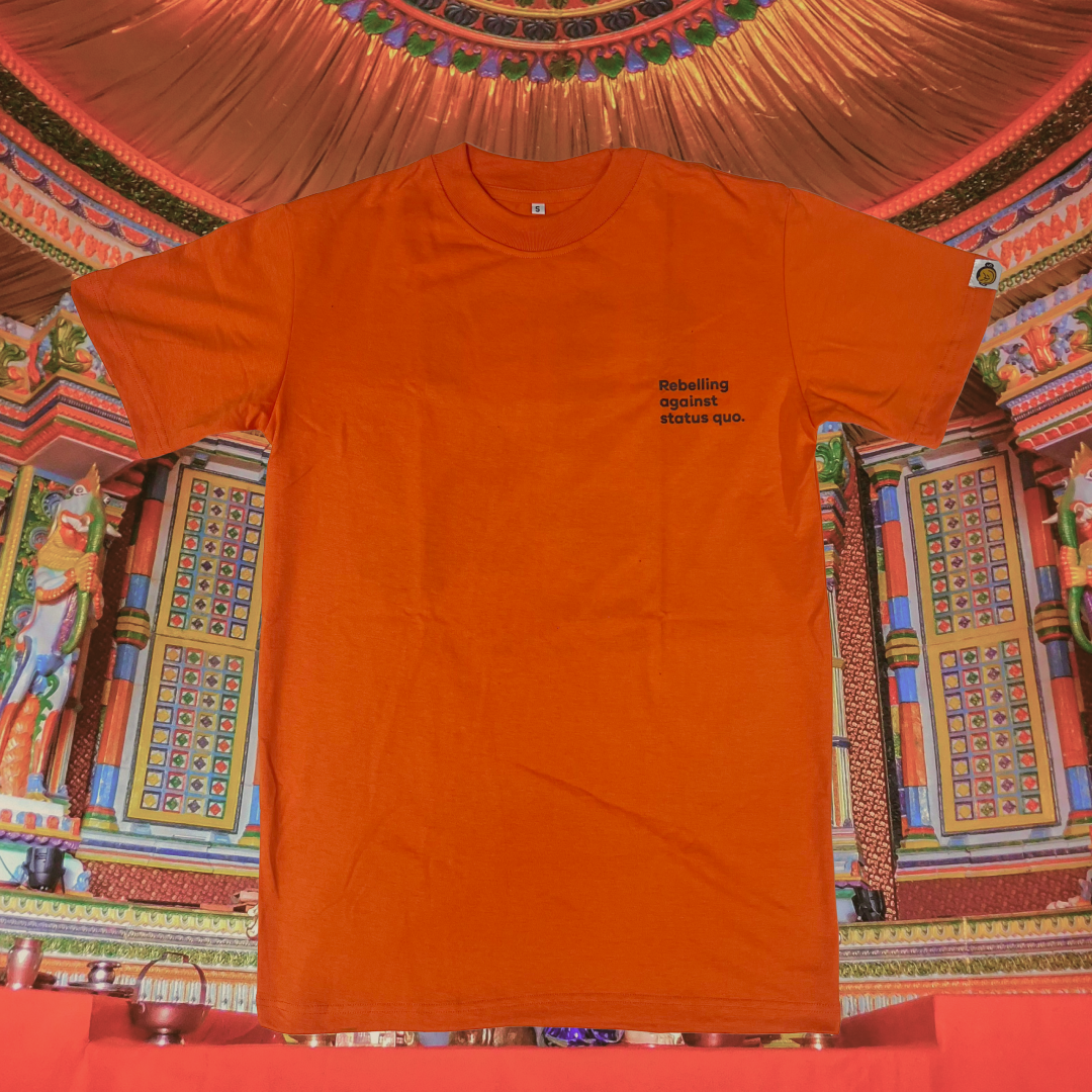 Orange t-shirt with text on a colorful, patterned background